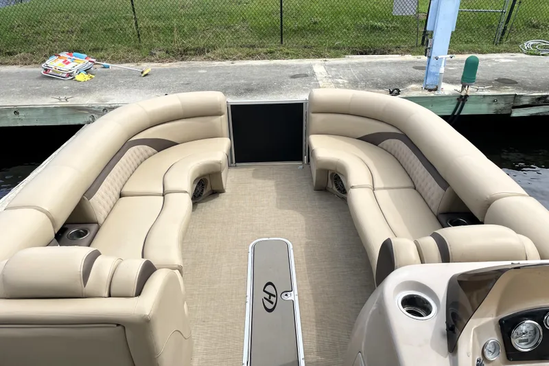 Slide: The Image of 2019 Harris Sunliner 250 pontoon boat with beige seating and spacious deck layout. - 7
