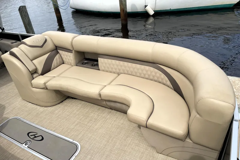 Slide: The Image of Luxurious seating on 2019 Harris Sunliner 250 pontoon boat, beige upholstery, waterfront view. - 9