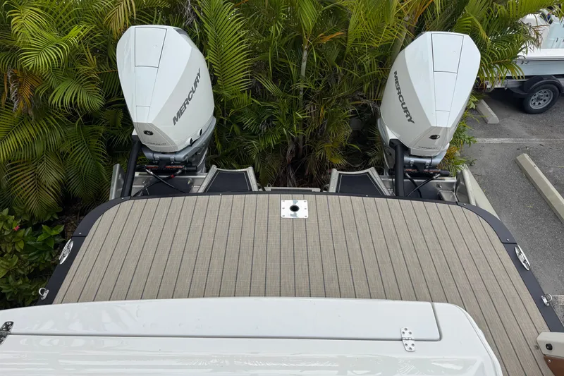Slide: The Image of 2026 Avalon Excalibur 27' boat with dual Mercury outboard motors, surrounded by lush greenery. - 36