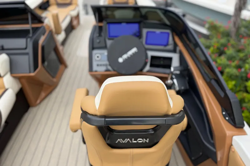 Slide: The Image of 2026 Avalon Excalibur 27' boat interior with tan seating and modern dashboard. - 44