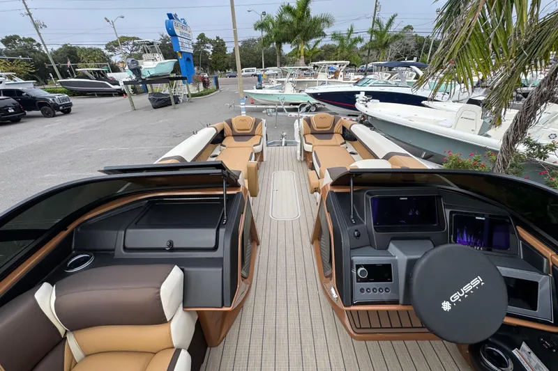Slide: The Image of 2026 Avalon Excalibur 27' luxury boat interior with modern dashboard and seating at a marina. - 48