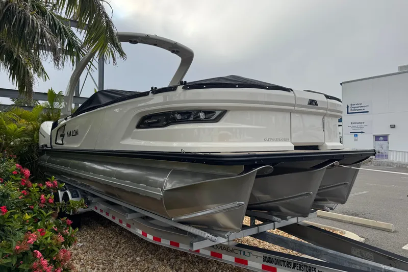 Slide: The Image of 2026 Avalon Excalibur 27' boat on trailer, surrounded by tropical plants. - 5