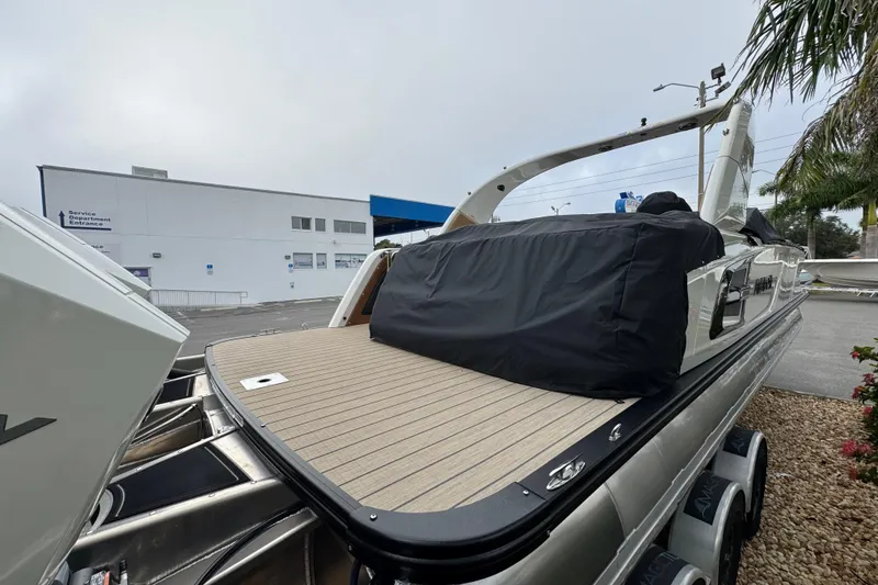 Slide: The Image of 2026 Avalon Excalibur 27' boat with sleek design, parked outdoors near service entrance. - 7
