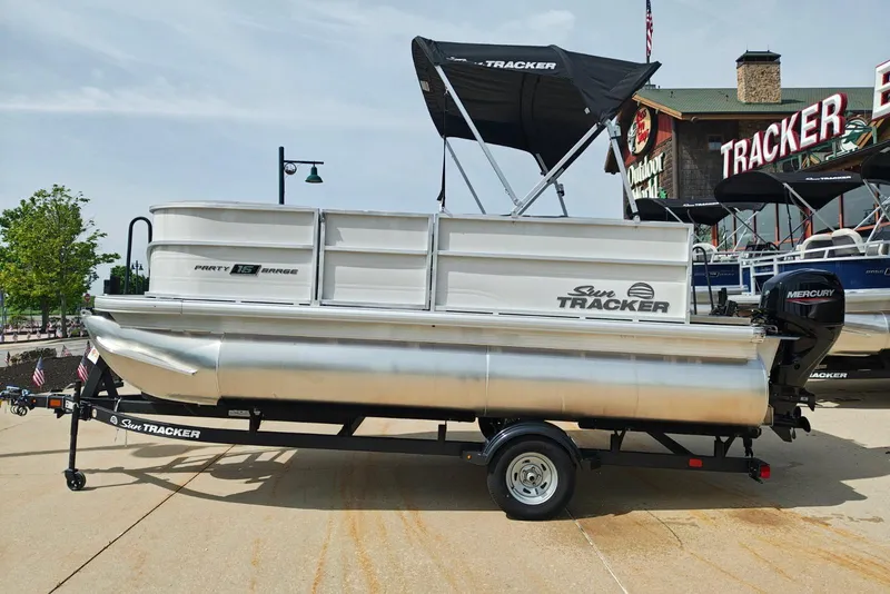 The Image of 2026 Sun Tracker Party Barge 16 DLX pontoon boat on trailer, outdoor display. - 0