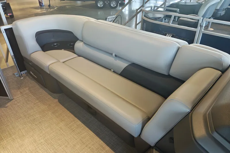 Slide: The Image of 2026 Sun Tracker Party Barge 20 DLX interior seating with beige upholstery and cup holders. - 18