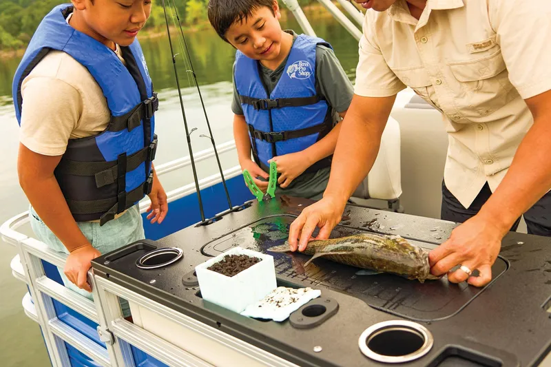 Slide: The Image of Open storage compartment on 2026 Sun Tracker Fishin' Barge 20 DLX boat. - 14