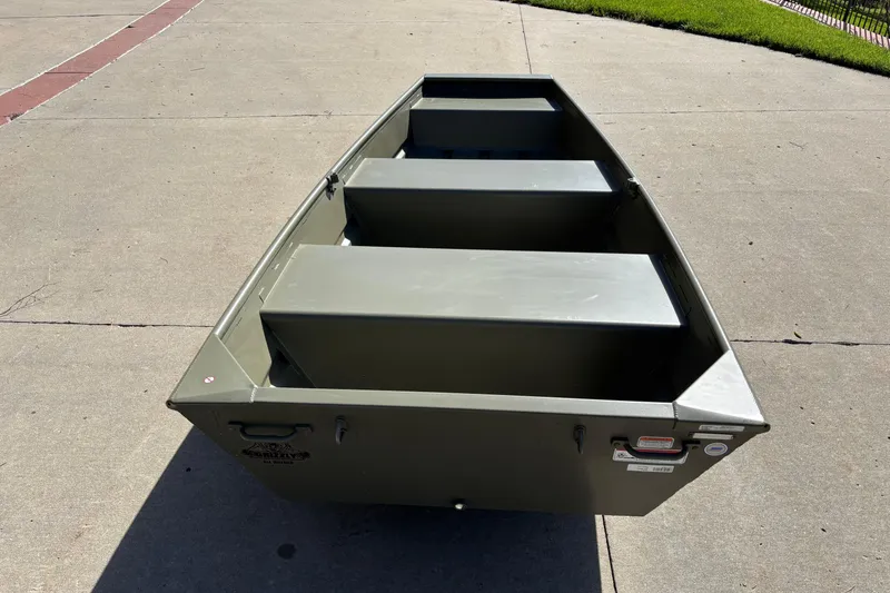 Slide: The Image of 2026 Tracker Grizzly 10 Jon boat on concrete surface, showcasing its sturdy design. - 2