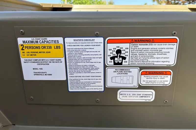 Slide: The Image of 2026 Tracker Grizzly 10 Jon boat safety labels and warnings, including capacity and carbon monoxide risks. - 3