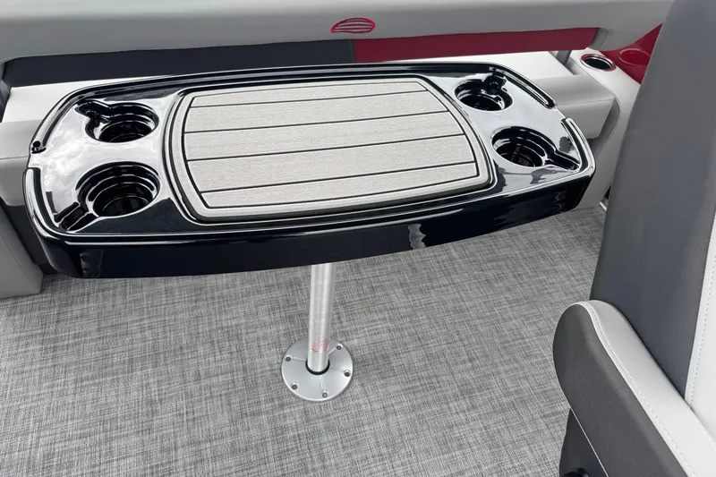 Slide: The Image of 2026 Sun Tracker Party Barge 22 RF DLX table with cup holders on a textured floor. - 12