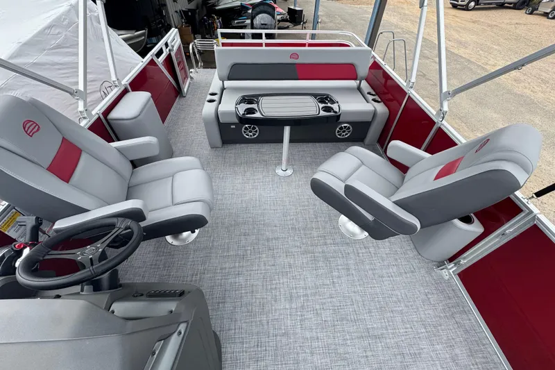 Slide: The Image of 2026 Sun Tracker Party Barge 22 RF DLX interior with gray and red seating, steering wheel, and table. - 17