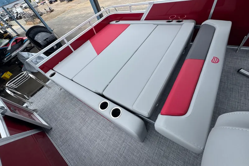 Slide: The Image of 2026 Sun Tracker Party Barge 22 RF DLX interior with red and gray seating and cup holders. - 20