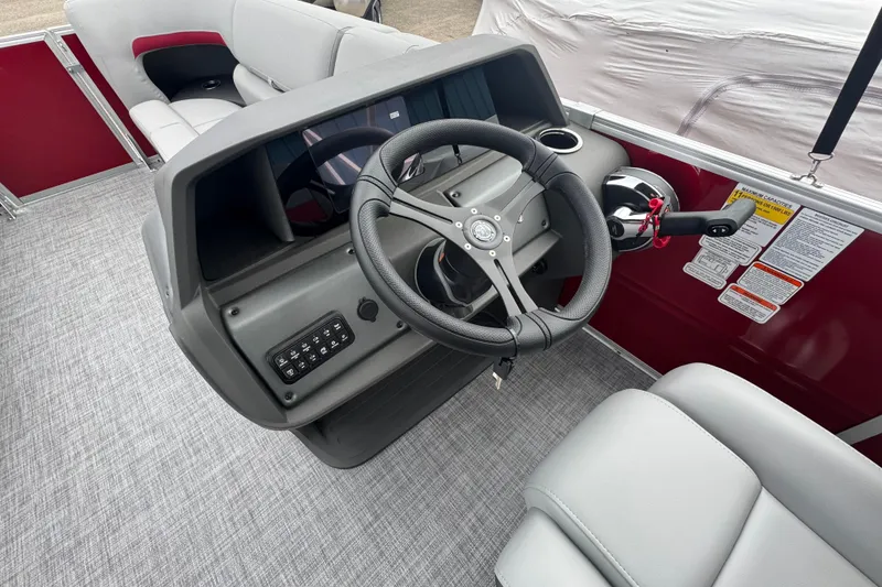 Slide: The Image of 2026 Sun Tracker Party Barge 22 RF DLX steering console with modern controls and seating. - 9