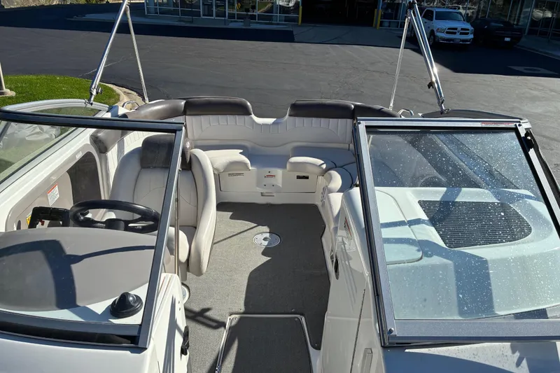 Slide: The Image of 2007 Yamaha Boats SX230 interior with seating and steering wheel, parked outdoors. - 10