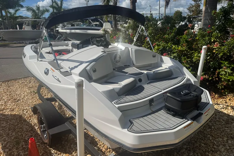 Slide: The Image of 2018 Scarab 165 G boat on trailer, parked outdoors with lush greenery. - 14