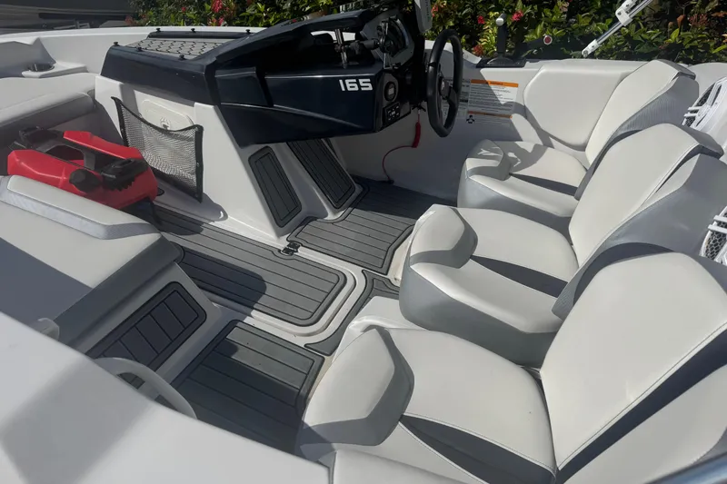 Slide: The Image of Interior of a 2018 Scarab 165 G boat with white seating and modern dashboard. - 15