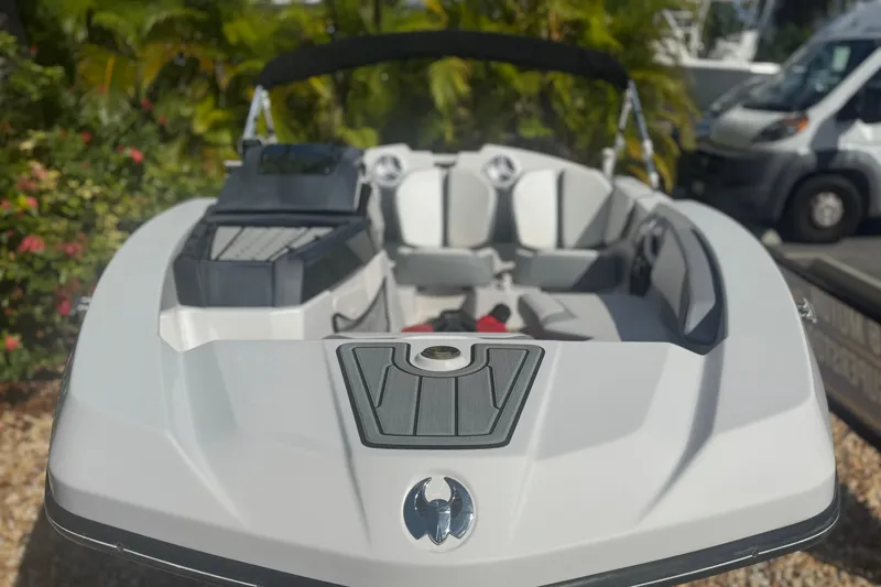 Slide: The Image of 2018 Scarab 165 G boat with sleek design, parked outdoors near greenery. - 4