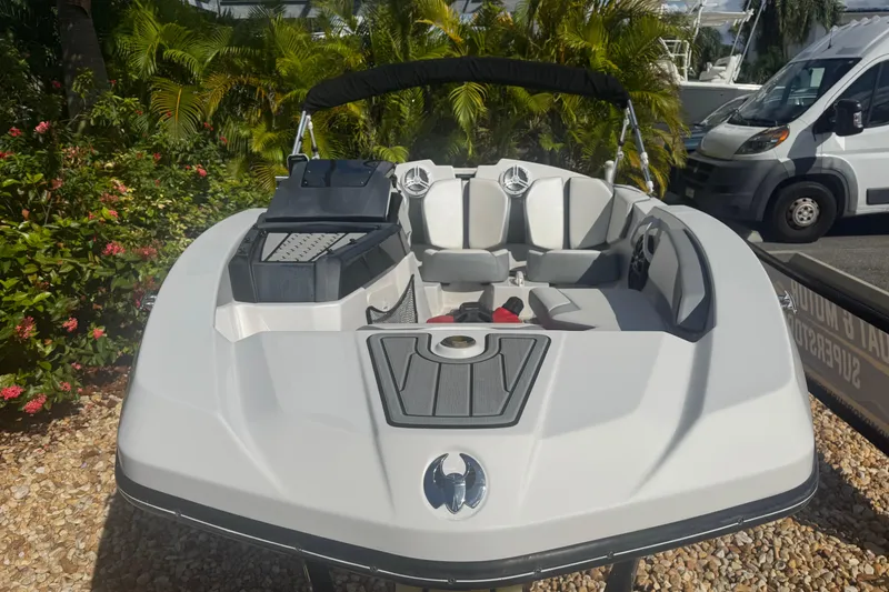 Slide: The Image of 2018 Scarab 165 G boat with sleek design, parked outdoors near lush greenery. - 5