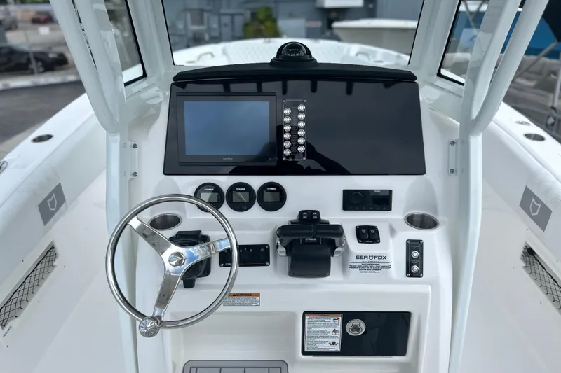 Slide: The Image of 2026 Sea Fox 268 Commander boat dashboard with steering wheel and navigation controls. - 2