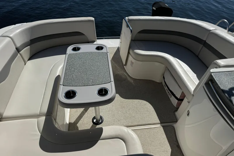 Slide: The Image of 2007 Chaparral Signature 330 boat interior with cushioned seating and table on calm water. - 10