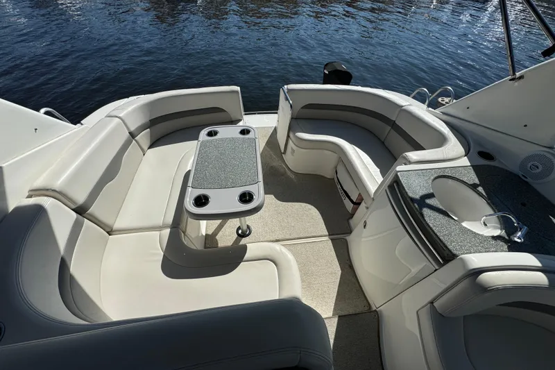 Slide: The Image of 2007 Chaparral Signature 330 boat interior with seating, table, and sink by the water. - 11