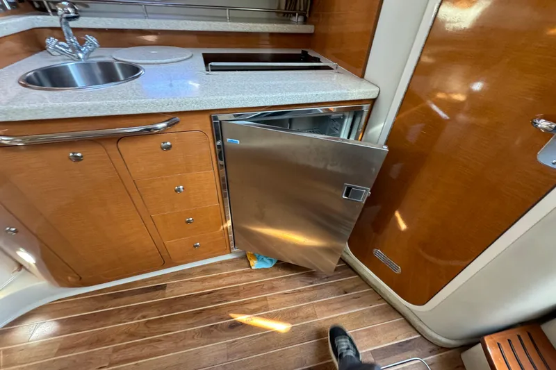 Slide: The Image of 2007 Chaparral Signature 330 yacht interior with kitchenette, stainless steel fridge, and wooden cabinetry. - 23