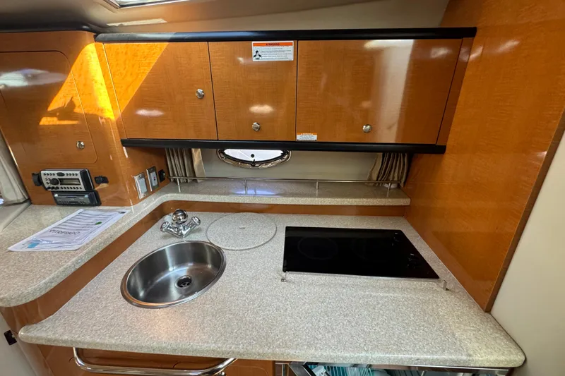 Slide: The Image of 2007 Chaparral Signature 330 yacht kitchen with sink, stove, and wooden cabinets. - 24