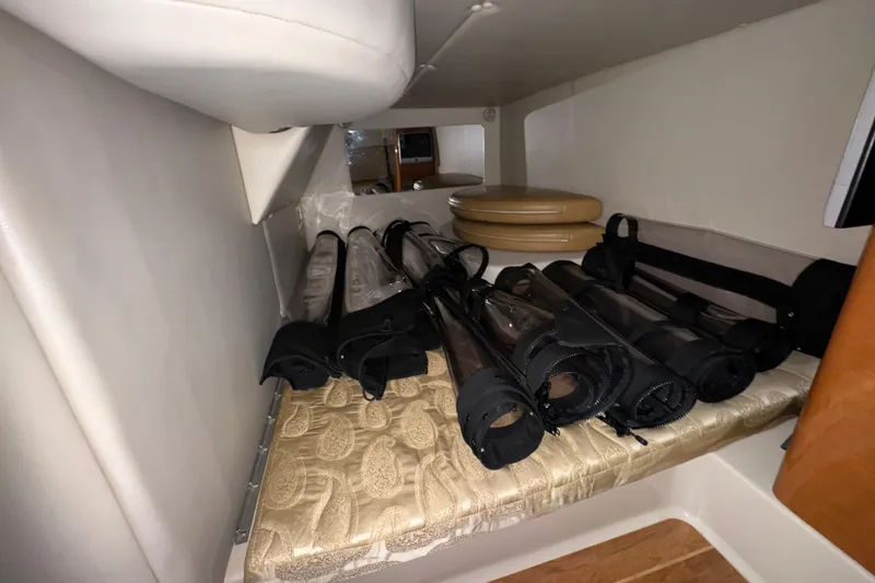 Slide: The Image of 2007 Chaparral Signature 330 interior storage with rolled covers and cushions. - 31