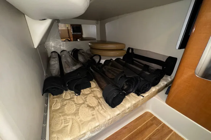 Slide: The Image of 2007 Chaparral Signature 330 interior storage area with rolled-up covers and cushions. - 32