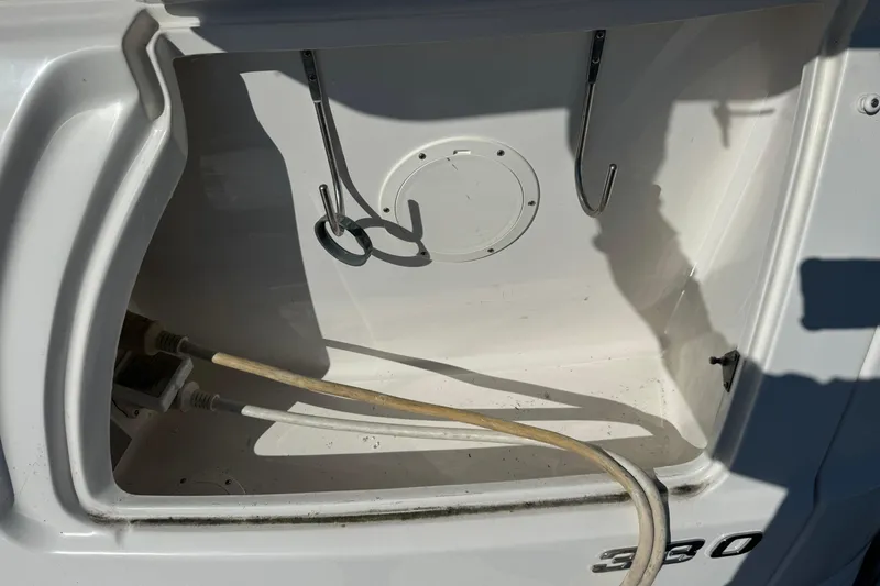 Slide: The Image of Storage compartment of 2007 Chaparral Signature 330 boat with hooks and hoses. - 9