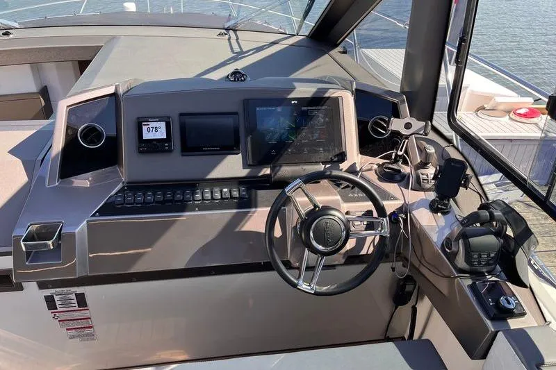 Slide: The Image of 2024 Galeon 425 HTS yacht helm with modern navigation controls and steering wheel. - 16
