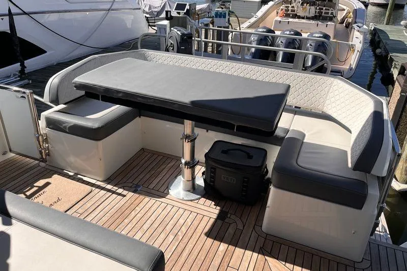 Slide: The Image of 2024 Galeon 425 HTS yacht deck with seating and table, docked at marina. - 7