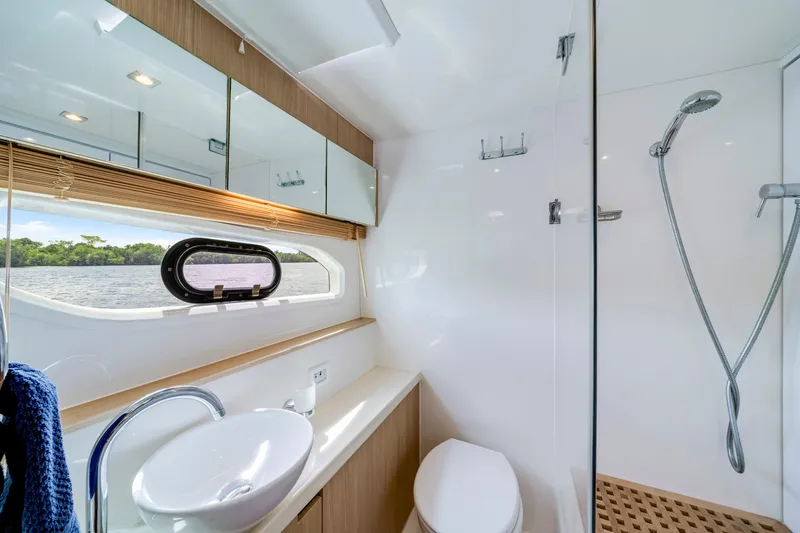 Slide: The Image of Luxurious cabin interior of 2019 Aquila 44 Yacht with nautical-themed bedding and scenic window view. - 28