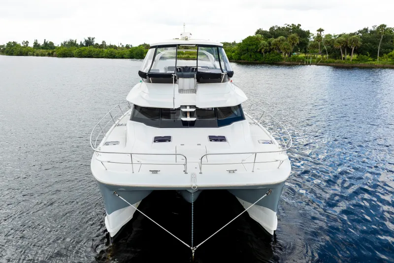 Slide: The Image of 2019 Aquila 44 Yacht on calm water, front view with lush greenery background. - 57
