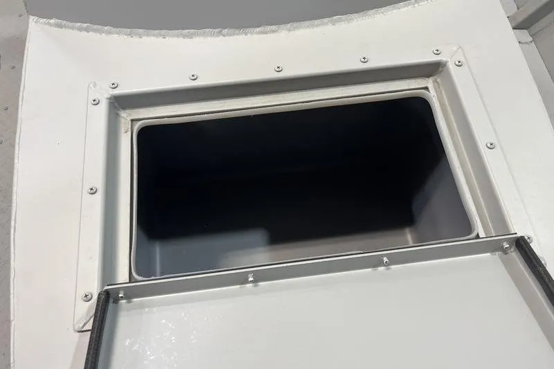 Slide: The Image of 2025 SeaArk 1860 MVJT boat compartment, open hatch view, white interior. - 13