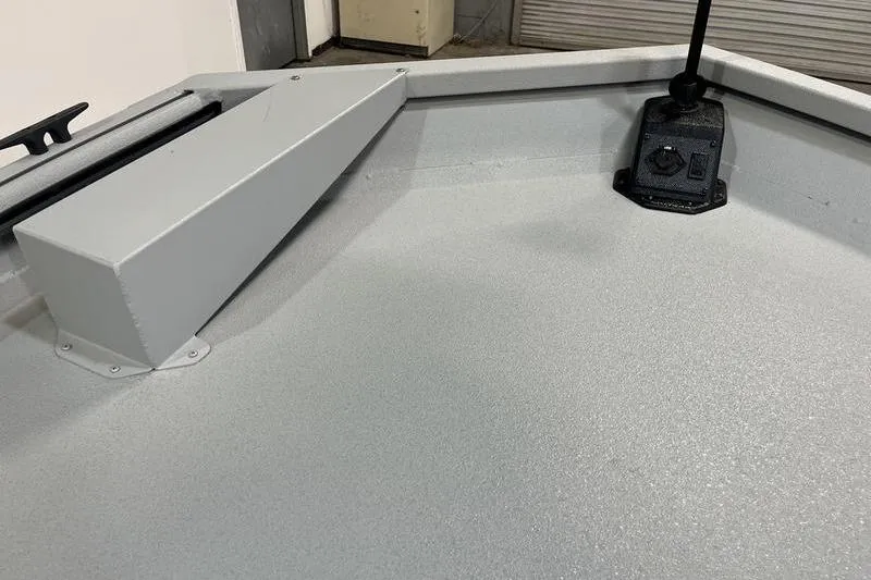 Slide: The Image of 2025 SeaArk 1860 MVJT boat interior with gray textured flooring and mounted equipment. - 15