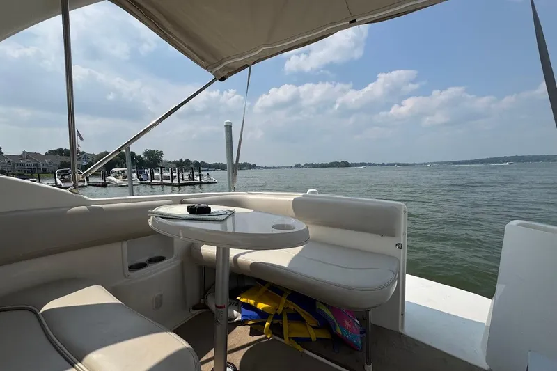 Slide: The Image of 2006 Larson Cabrio 274 boat interior with lake view, featuring seating and table. - 8