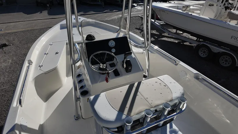 Slide: The Image of 2025 Bulls Bay 2200XS boat interior with steering console and rod holders. - 16