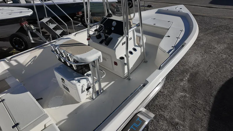 Slide: The Image of 2025 Bulls Bay 2200XS boat, white interior, center console, docked on gravel surface. - 8