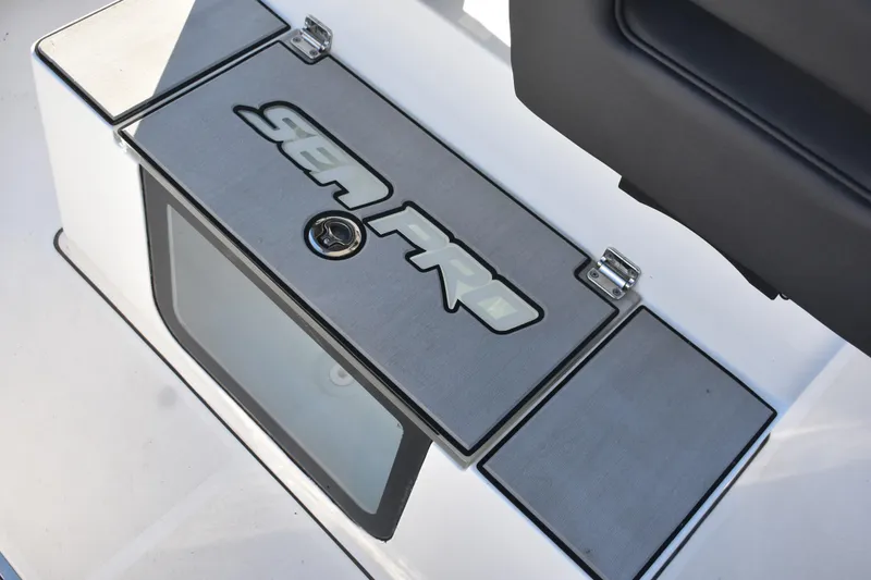 Slide: The Image of 2025 Sea Pro 245FLX Sandbar boat compartment with logo and latch. - 13