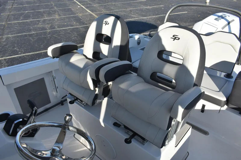 Slide: The Image of 2025 Sea Pro 245FLX Sandbar boat interior with dual captain's chairs and steering wheel. - 7