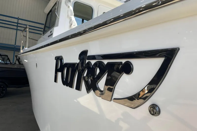 Slide: The Image of 2026 Parker 217 Explorer boat logo on white hull in a showroom. - 18