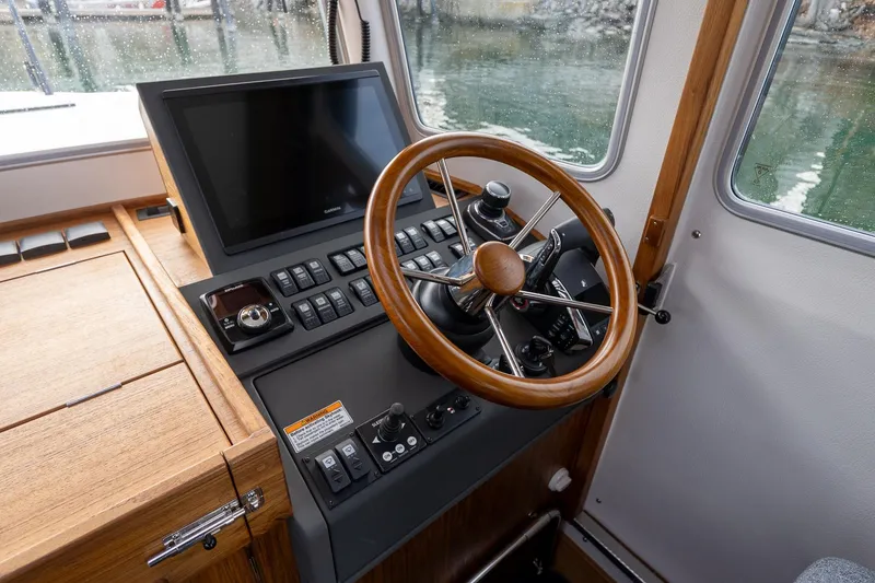 Slide: The Image of 2026 Targa 27.2 boat helm with wooden steering wheel and modern navigation controls. - 48