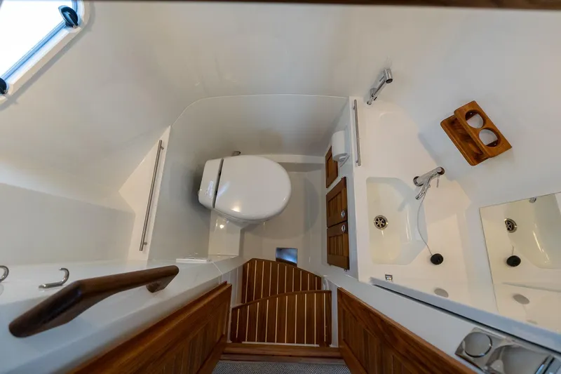 Slide: The Image of 2026 Targa 27.2 boat bathroom interior with toilet, sink, and wooden accents. - 59