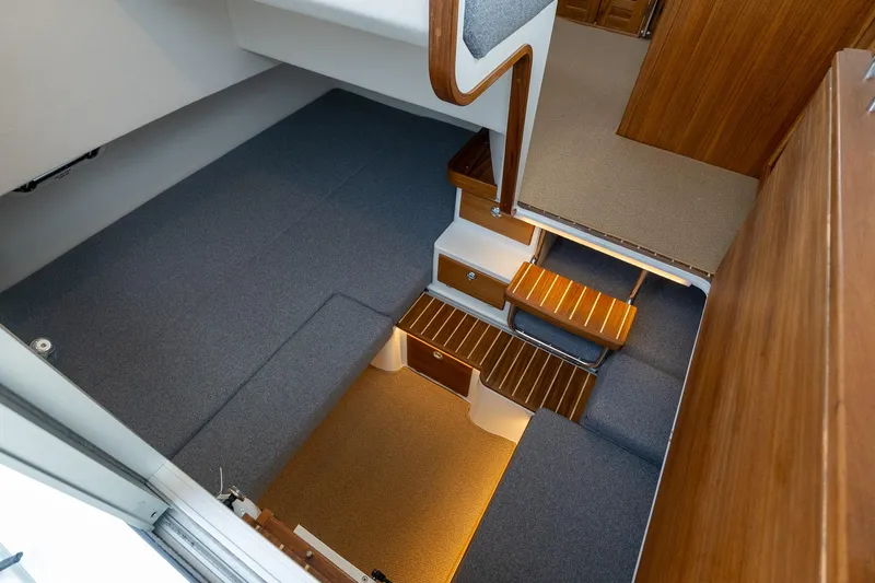 Slide: The Image of Interior of 2026 Targa 27.2 boat, featuring wooden steps and carpeted seating area. - 76