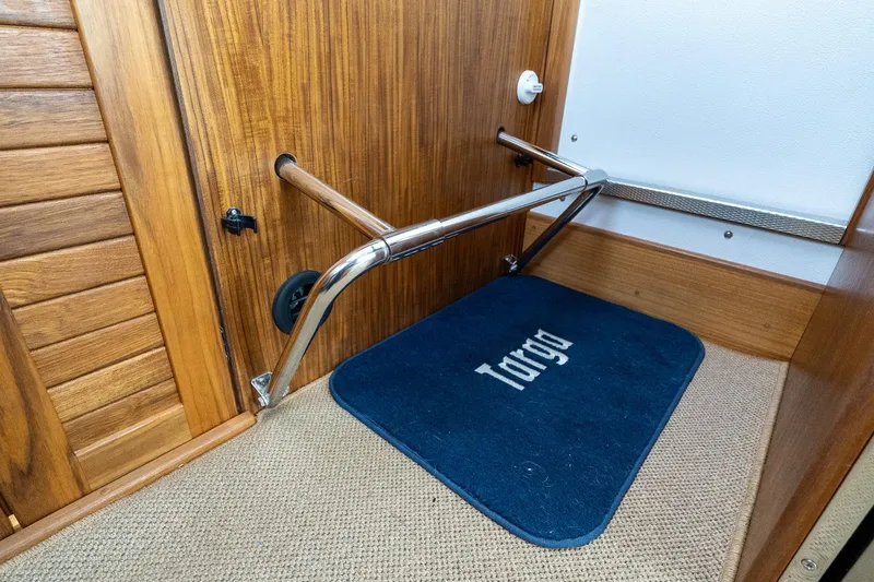 Slide: The Image of Interior of 2026 Targa 27.2 boat with wooden paneling and branded mat. - 82