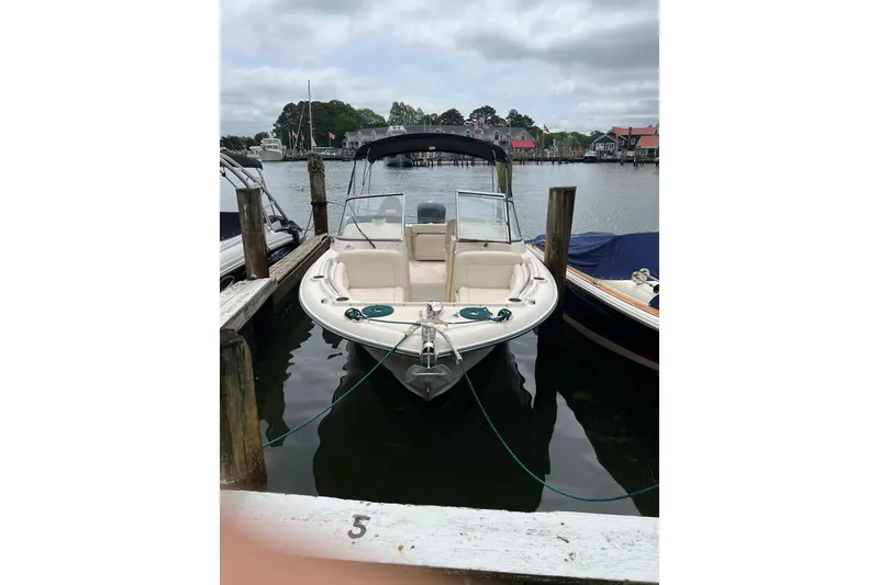 Slide: The Image of 2019 Grady-White Freedom 235 boat docked at a marina, overcast sky. - 2