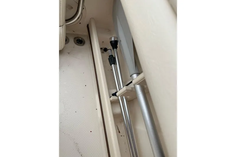 Slide: The Image of Storage compartment in a 2019 Grady-White Freedom 235 boat, featuring secured metal poles. - 30