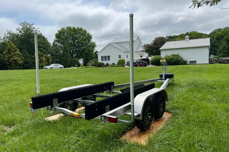 Slide: The Image of Trailer for 2019 Grady-White Freedom 235 boat on grassy lawn near white house. - 38