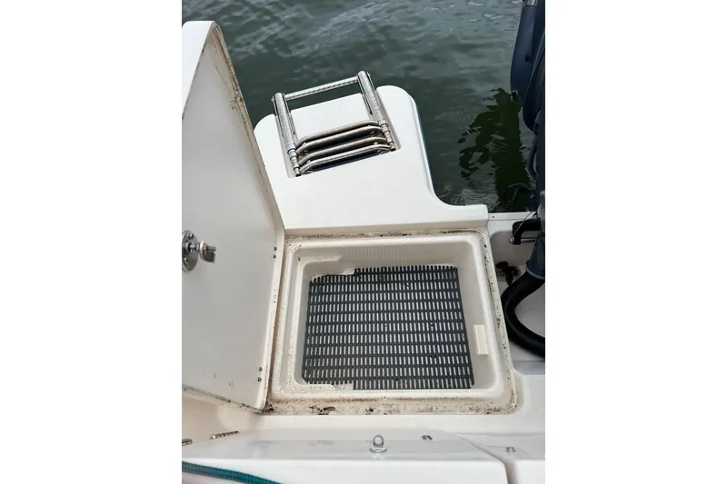 Slide: The Image of 2019 Grady-White Freedom 235 boat with open hatch and ladder near water. - 6