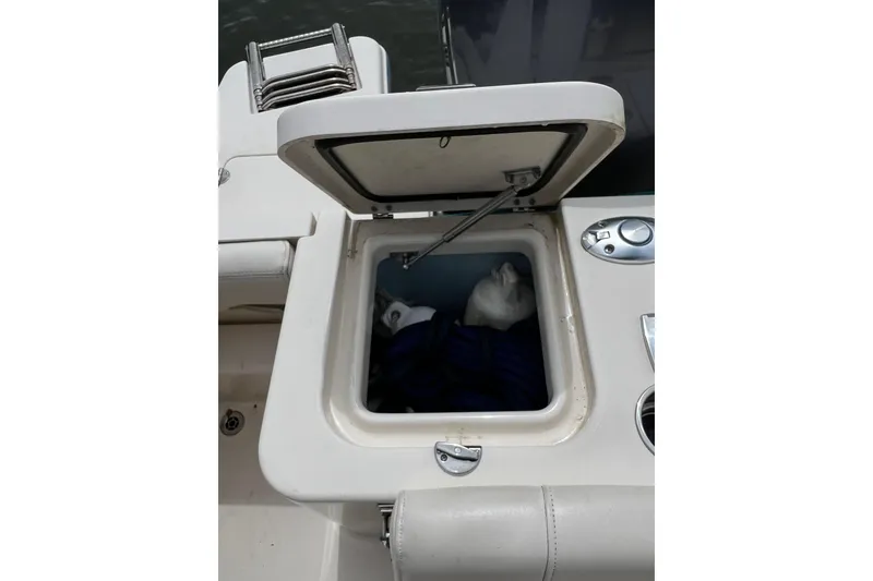 Slide: The Image of Open storage compartment on 2019 Grady-White Freedom 235 boat, showing interior contents. - 7